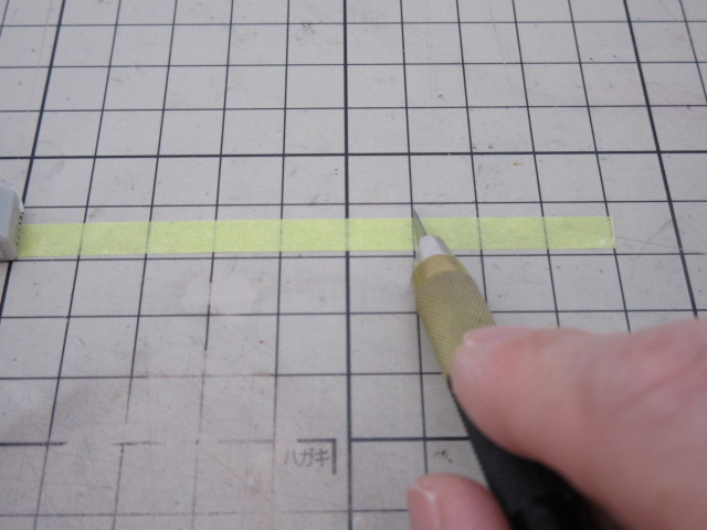 デザインナイフで舞うキングテープをカットしている様子