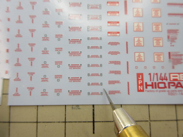 デザインナイフで水転写式デカールをカットしている様子