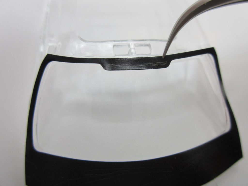 楽プラのフロントガラスでシール貼りの位置合わせをしている画像