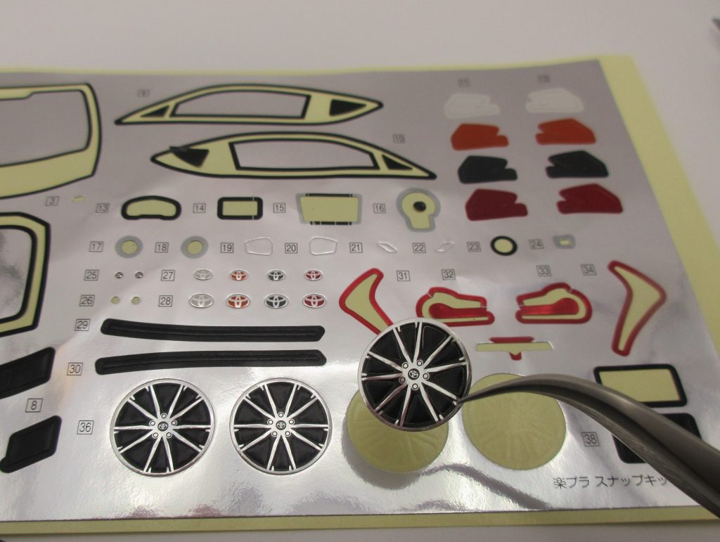 楽プラ８６のホイールのシールを台紙から剥がしている画像